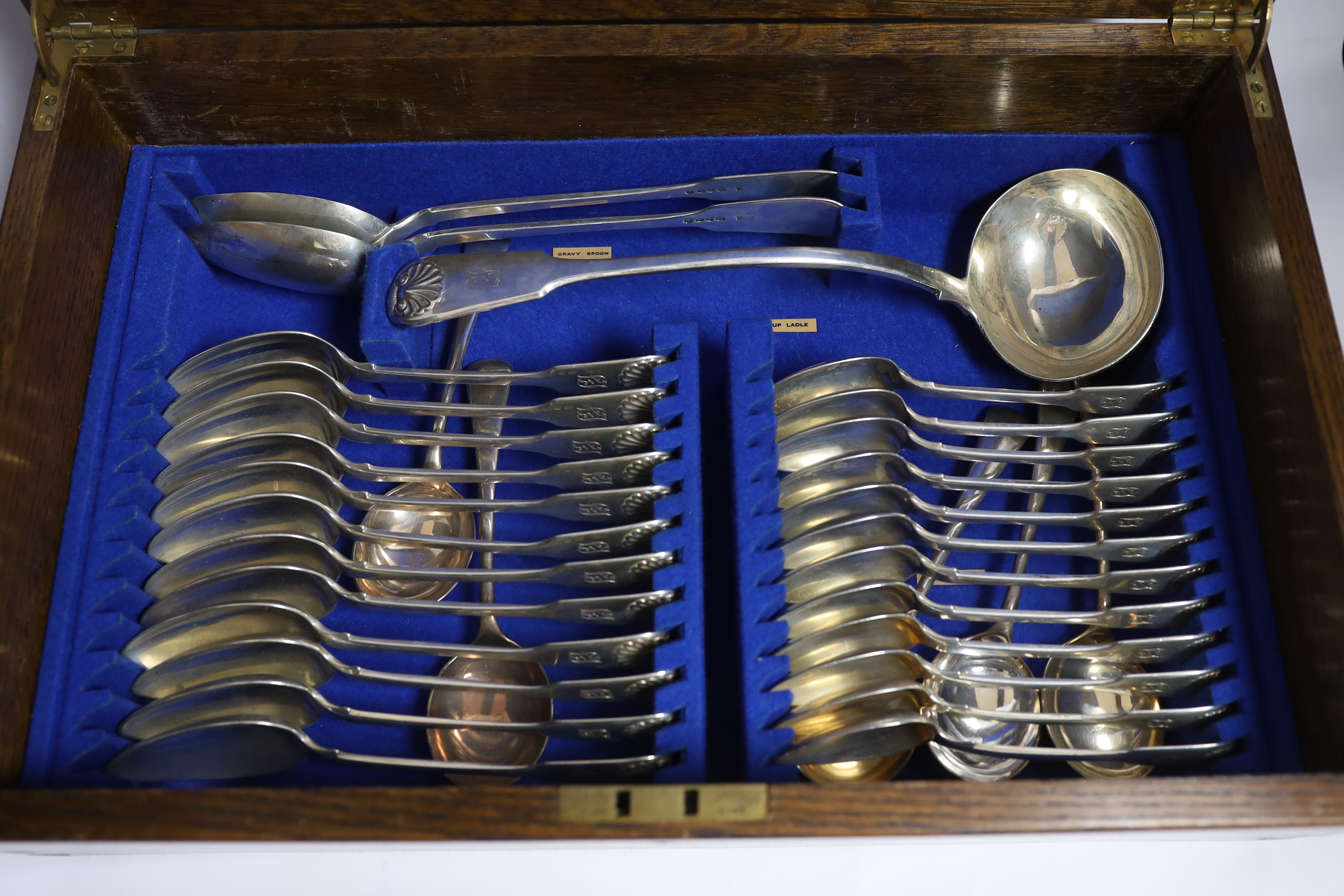 A Victorian oak cased matched canteen of silver fiddle and shell pattern flatware, by John & Henry Lias & H.J. Lias & Son